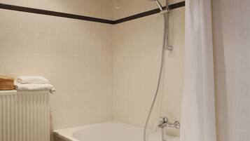 Une salle de bain moderne équipée d’une baignoire, d’une douche et d’un porte-serviettes.