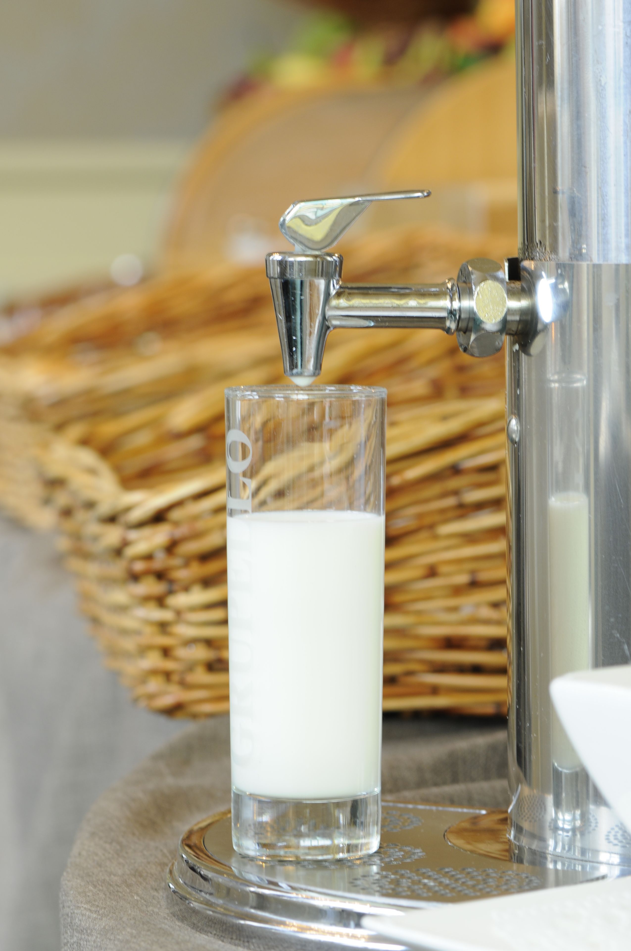 A glass of milk being dispensed from a tap.