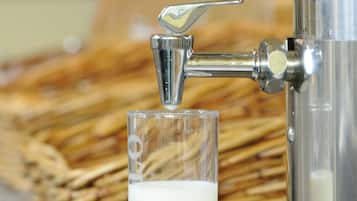A glass of milk being dispensed from a tap.