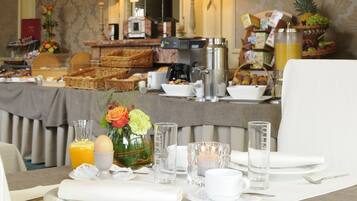 A breakfast buffet setup with various food items and a coffee station.