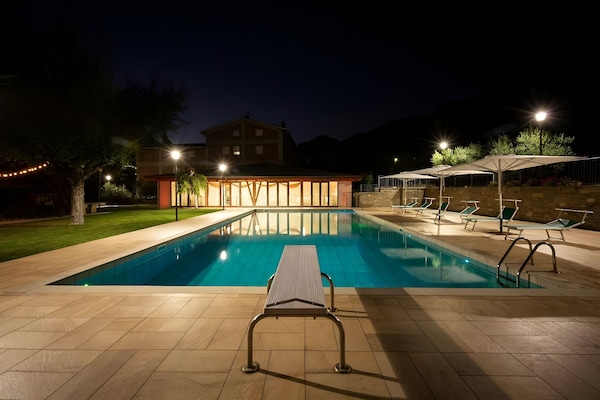 Una piscina al aire libre, sombrillas, tumbonas