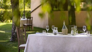 A table set outdoors with a tablecloth, glasses, and a pitcher. - Catignano Hotel (Gubbio)
