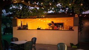 An outdoor bar area with string lights, a counter, and seating. - Catignano Hotel (Gubbio)