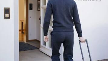 A man in a dark suit walking towards a door labeled "Altes Försterhaus."