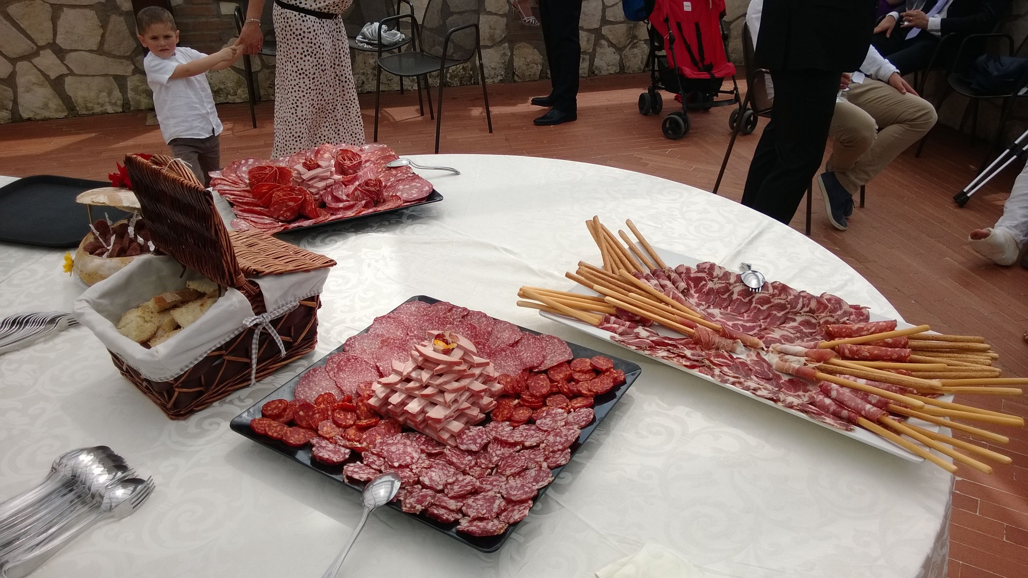 Une table où sont présentés différents types de charcuteries et de gressins, probablement préparée pour une réception ou un événement.