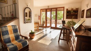 A spacious living area with a wooden chair, a wooden table, and a potted plant.