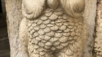 A stone owl sculpture with detailed feathers and a prominent beak.