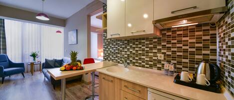 Una cocina moderna con armarios de madera, un lavamanos de acero inoxidable y una cafetera.