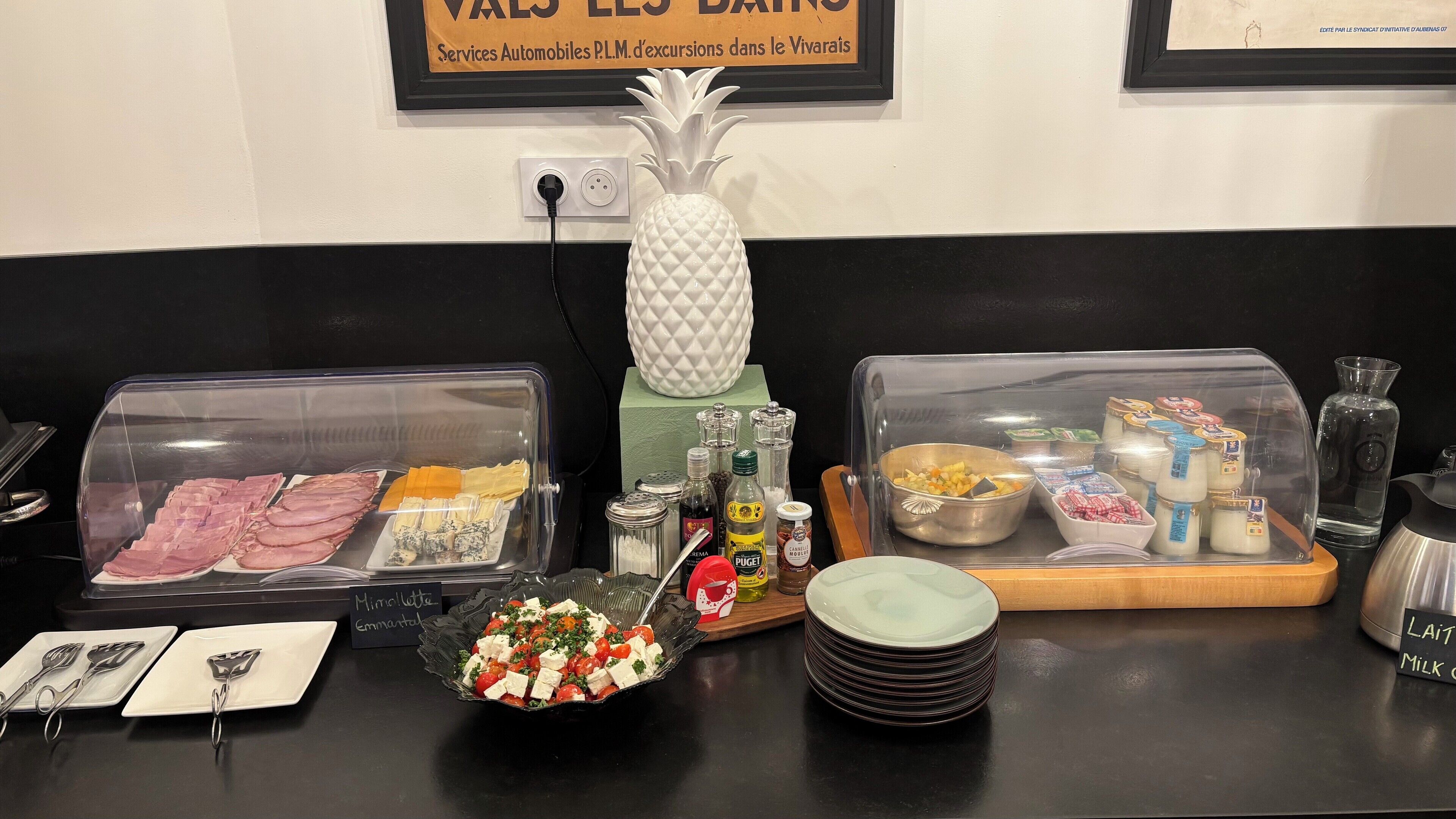 Ein reichhaltiges Buffet mit verschiedenen Speisen und Beilagen, darunter Schinken, Käse und Salat.