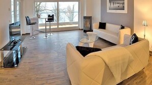 Ein modernes Wohnzimmer mit einer Couch, einem Couchtisch und einer TV-Konsole.