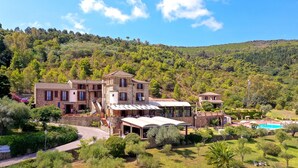 A large stone building with multiple rooms, a swimming pool, and a lush garden. - Hotel Hermitage (Castellabate)