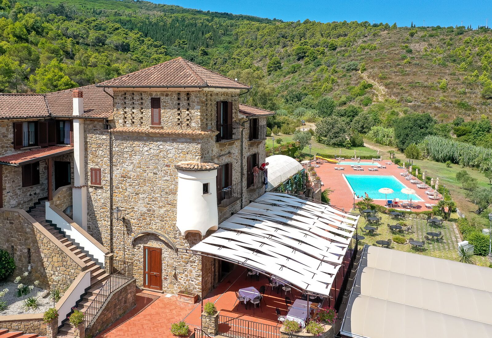 A stone building with a pool and outdoor seating.