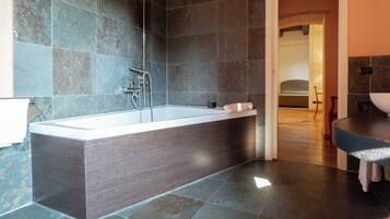 Un baño moderno con una bañera independiente, un lavabo separado y una zona de ducha.