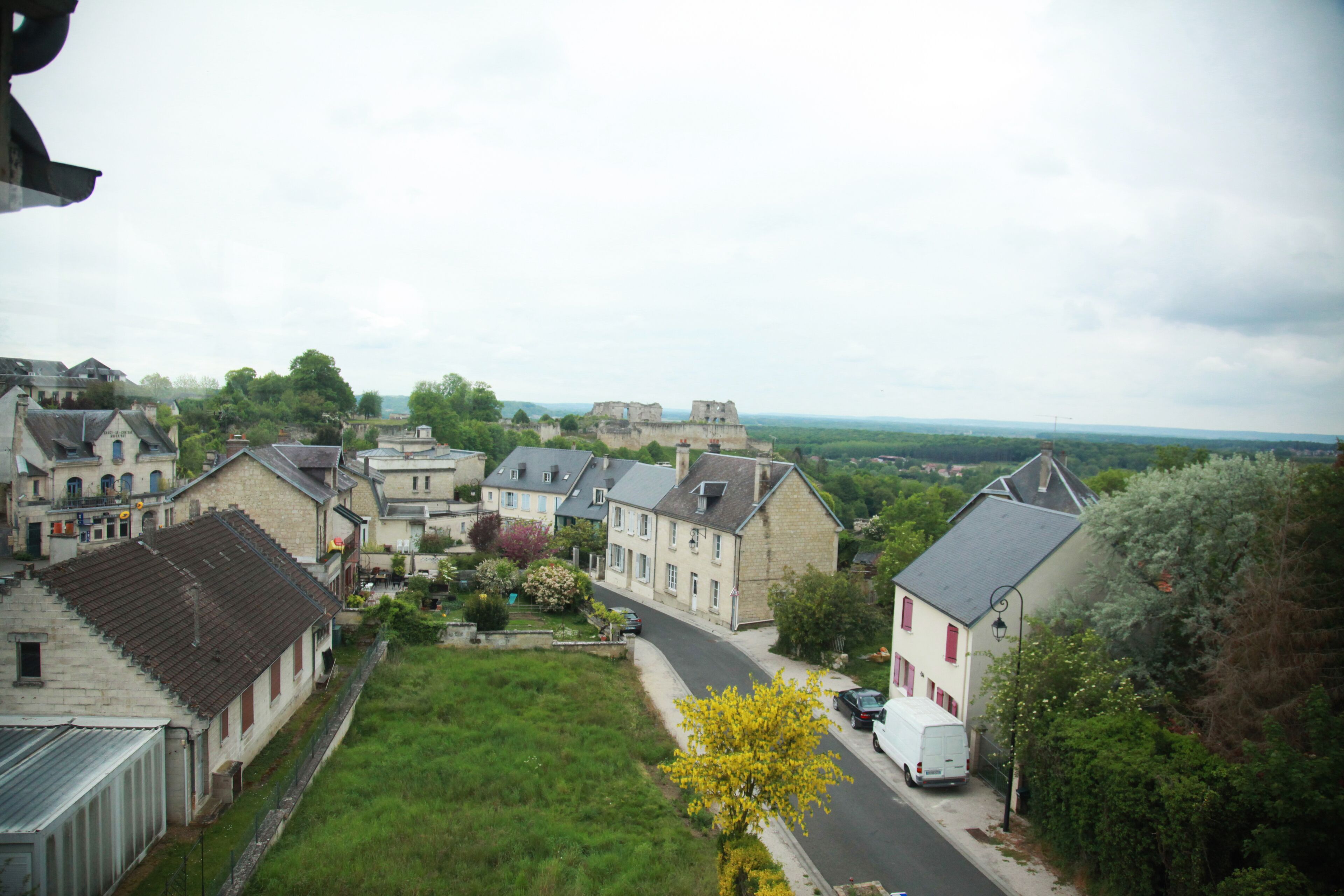 Zona residencial com casas, uma estrada e um castelo ao longe.