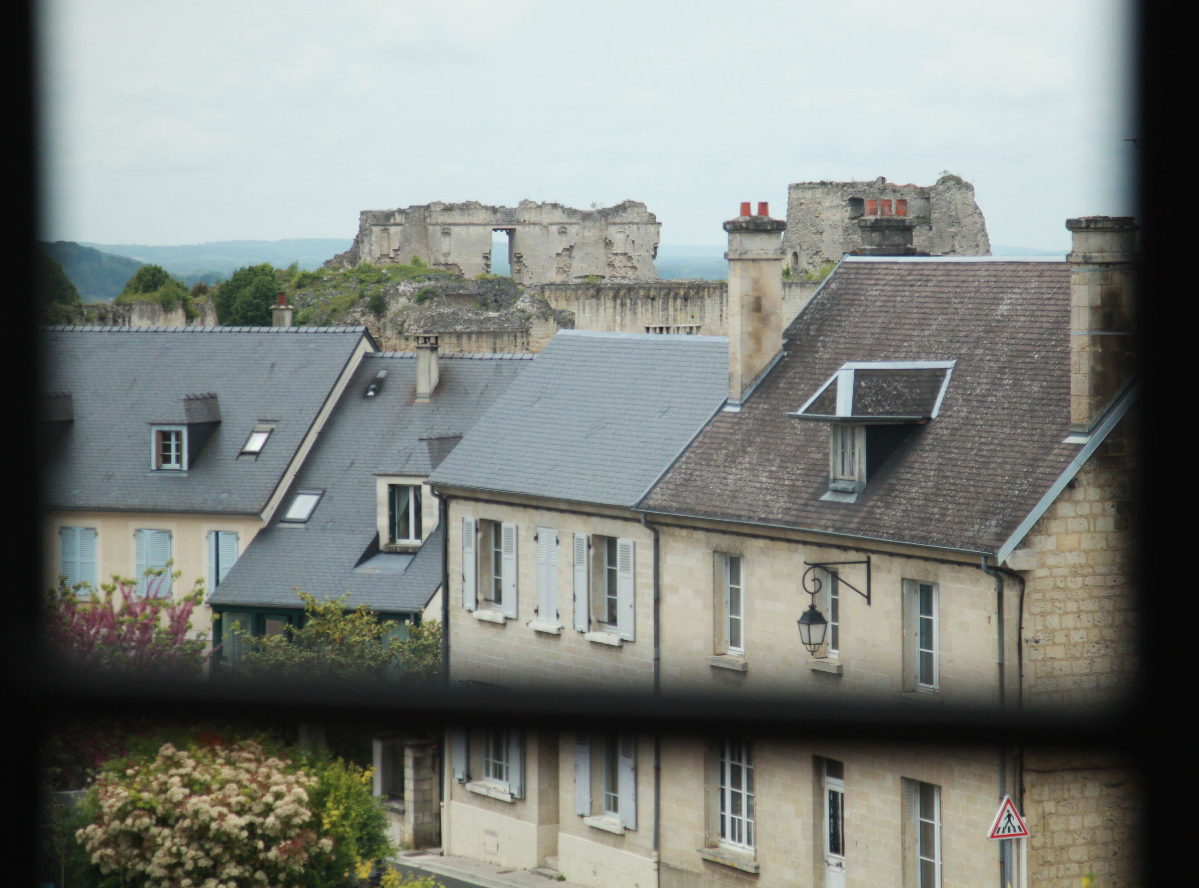 A row of residential buildings with a historical stone structure in the background.