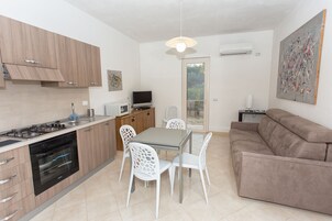 Una cocina moderna con comedor, sofá y televisor.