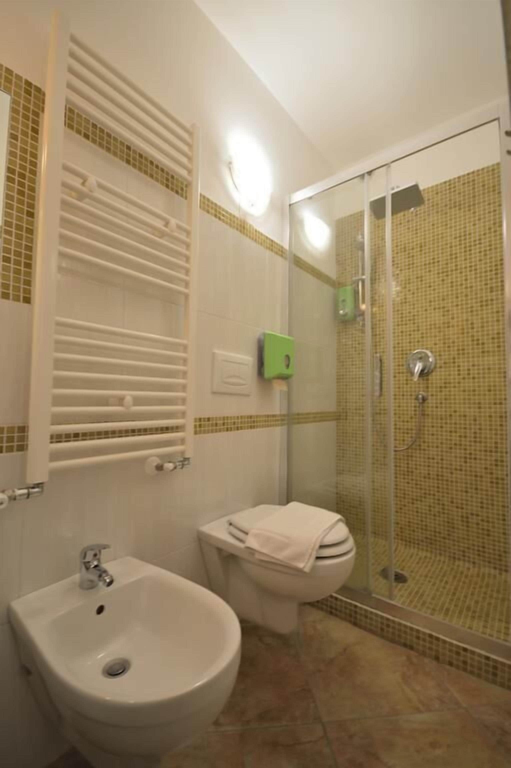 A bathroom with a sink, toilet, and glass-enclosed shower.