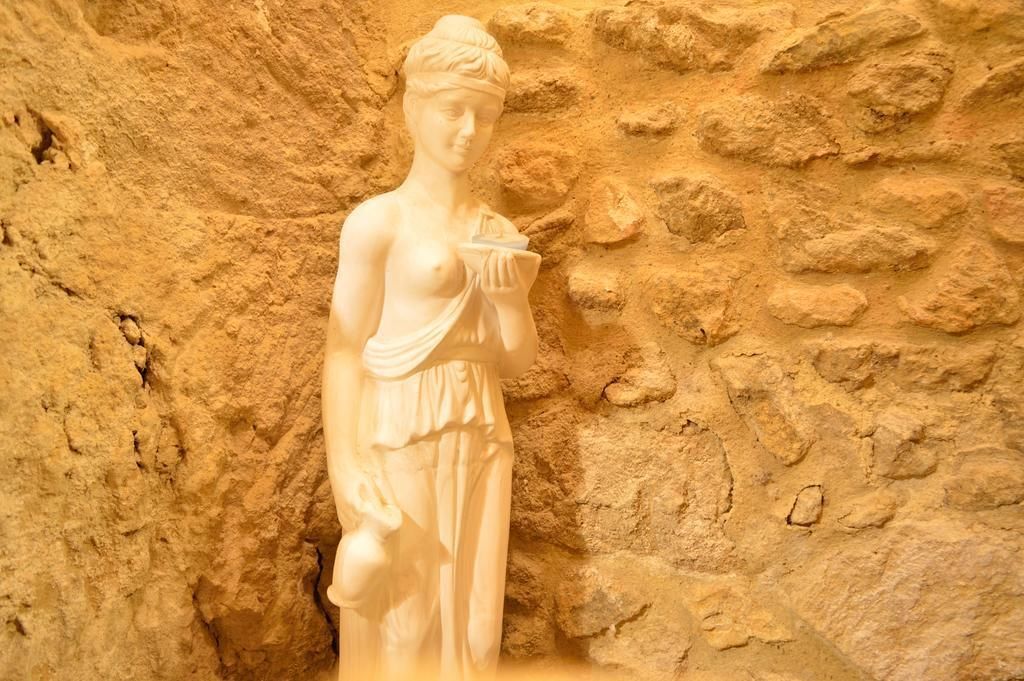A classical statue in a stone-walled room.