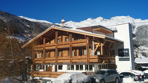 A wooden chalet with a balcony, a bell tower, and a sign for 'SPORALM'. - Pension Sportalm (Soelden)
