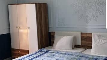 Een slaapkamer met een bed, een garderobe en een decoratief wandpaneel.