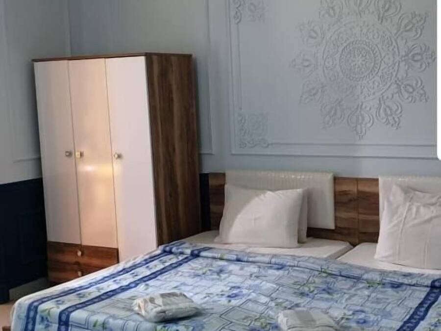 Een slaapkamer met een bed, een garderobe en een decoratief wandpaneel.