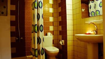 A bathroom with a toilet, sink, and shower curtain.