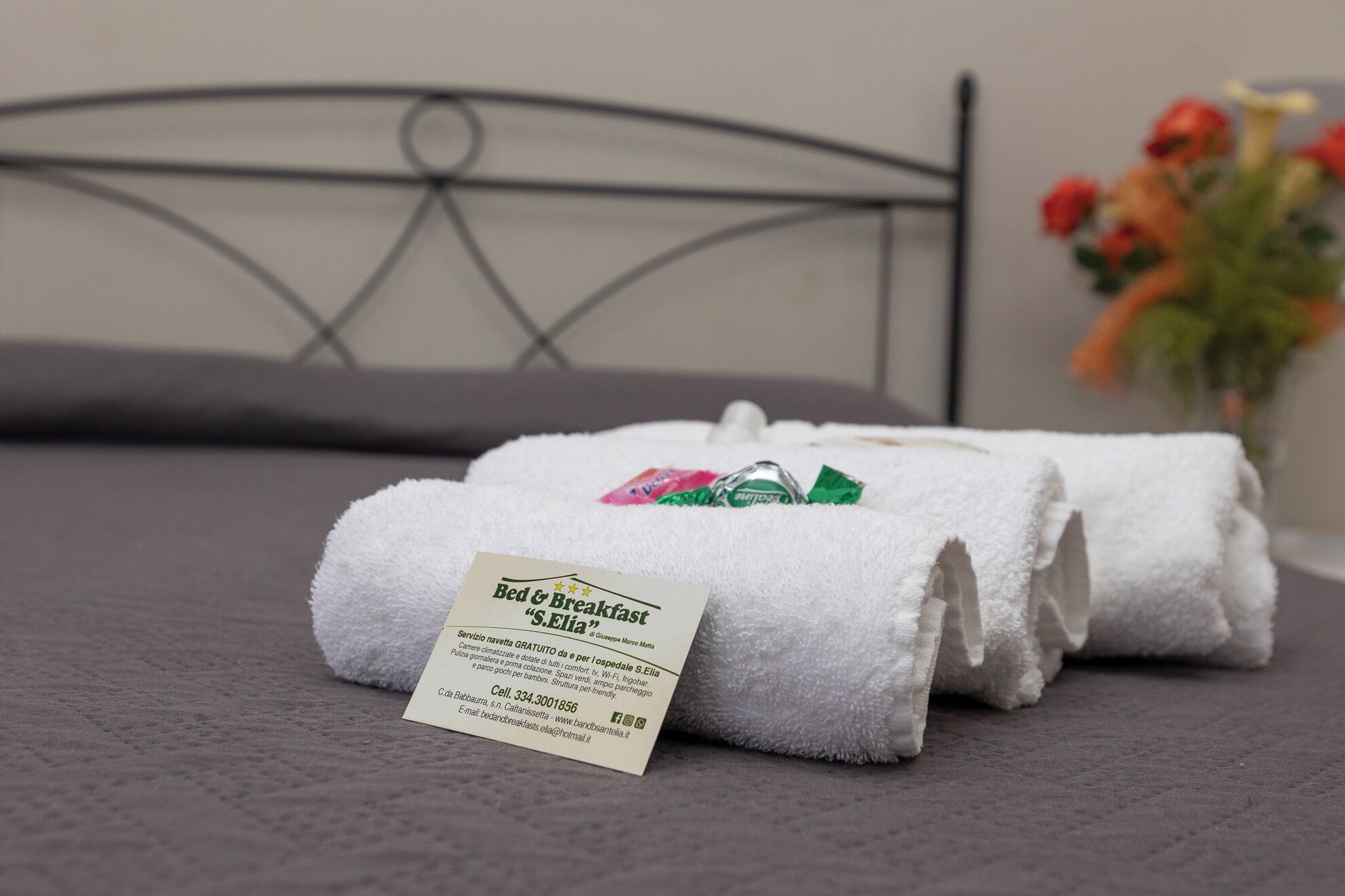 Cama bem arrumada com etiqueta indicando serviço de café da manhã.