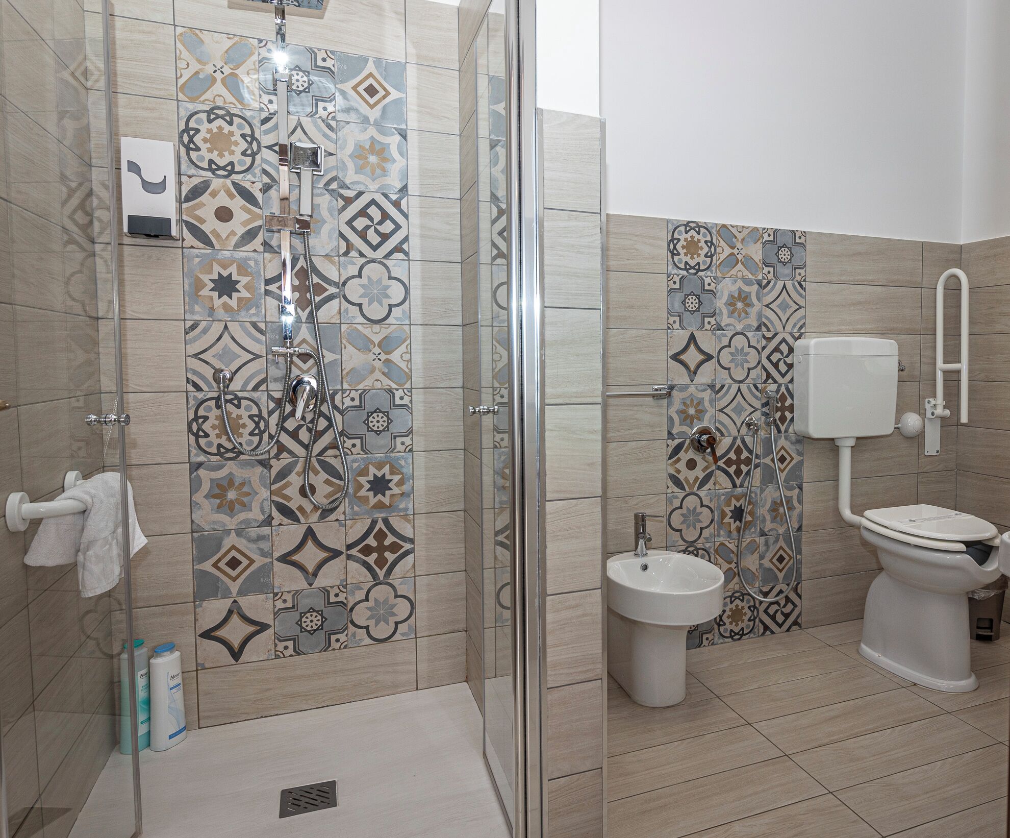 Une salle de bain équipée d’une douche, de toilettes, d’un bidet et d’un lavabo.