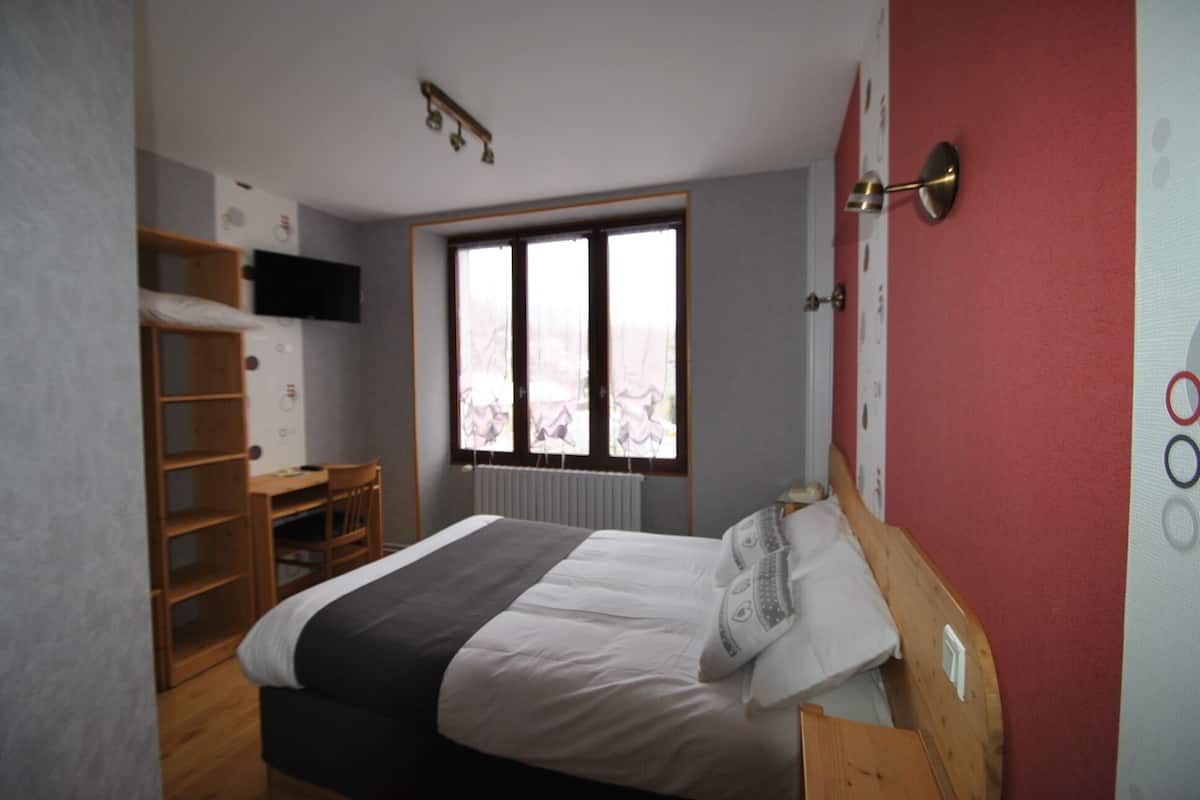 Une chambre à coucher avec un lit, un bureau et une fenêtre.