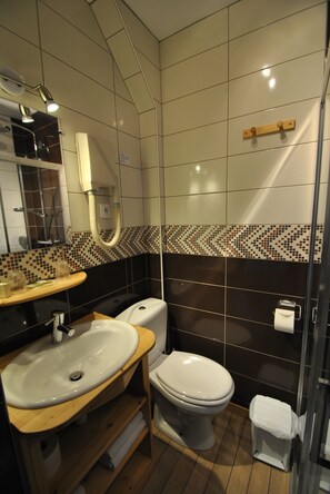 Een moderne badkamer met een wastafel, toilet en douche.