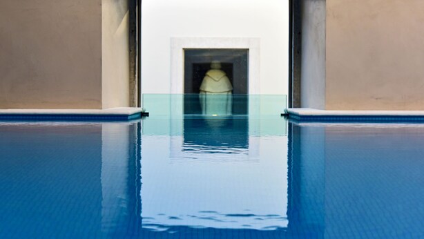 A swimming pool with a clear view of a statue in the background. - Pousada de Lisboa - Small Luxury Hotels Of The World (Lisbon)