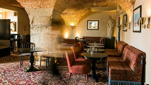 A dining area with brick ceiling, patterned carpet, and a mix of seating including a sofa and chairs. - Pousada de Lisboa - Small Luxury Hotels Of The World (Lisbon)