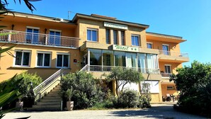 A two-story hotel with a balcony, a staircase, and a sign that reads "Hotel". - Hotel Le Clément V (Roquemaure)