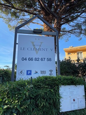Señal de Hotel Le Clement V con servicios como estacionamiento, Logis Hotels y WiFi.