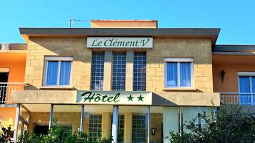 Et hotel kaldet "Le Clément V" med et skilt, der angiver tre stjerner.