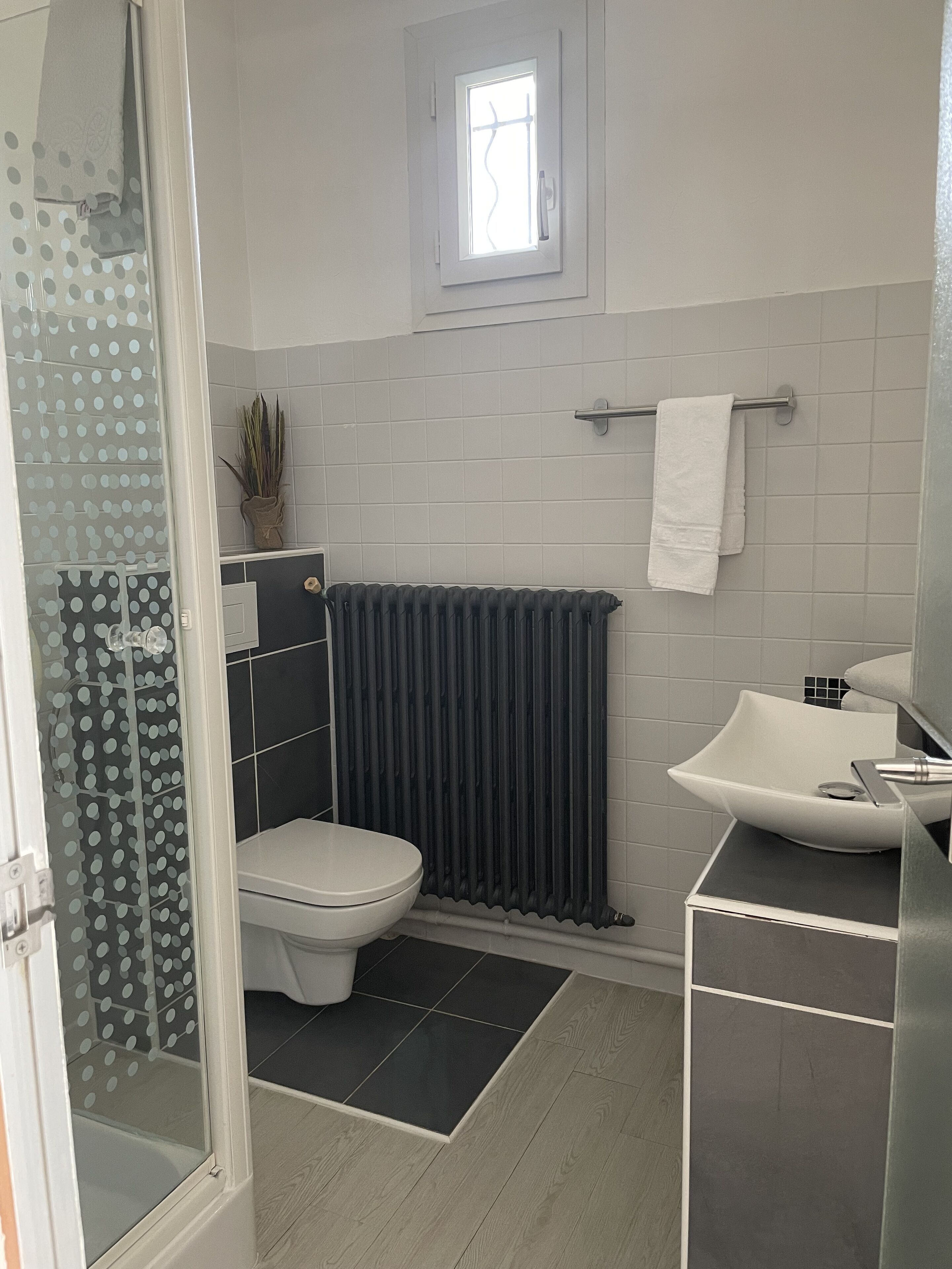 Une salle de bain moderne équipée de toilettes, d’un lavabo et d’un espace douche.