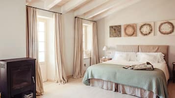 Um quarto com uma cama, mesa de cabeceira, abajur e lareira.