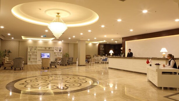 A hotel lobby with a reception desk, seating area, and a large chandelier. - Luxor Garden Hotel (Izmit)