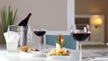 Una mesa servida con copas de vino, una botella y una variedad de aperitivos.