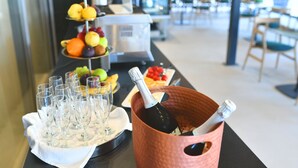 A buffet table with a variety of fruits, a bottle of champagne, and several glasses. - Hotel Milenij (Makarska)
