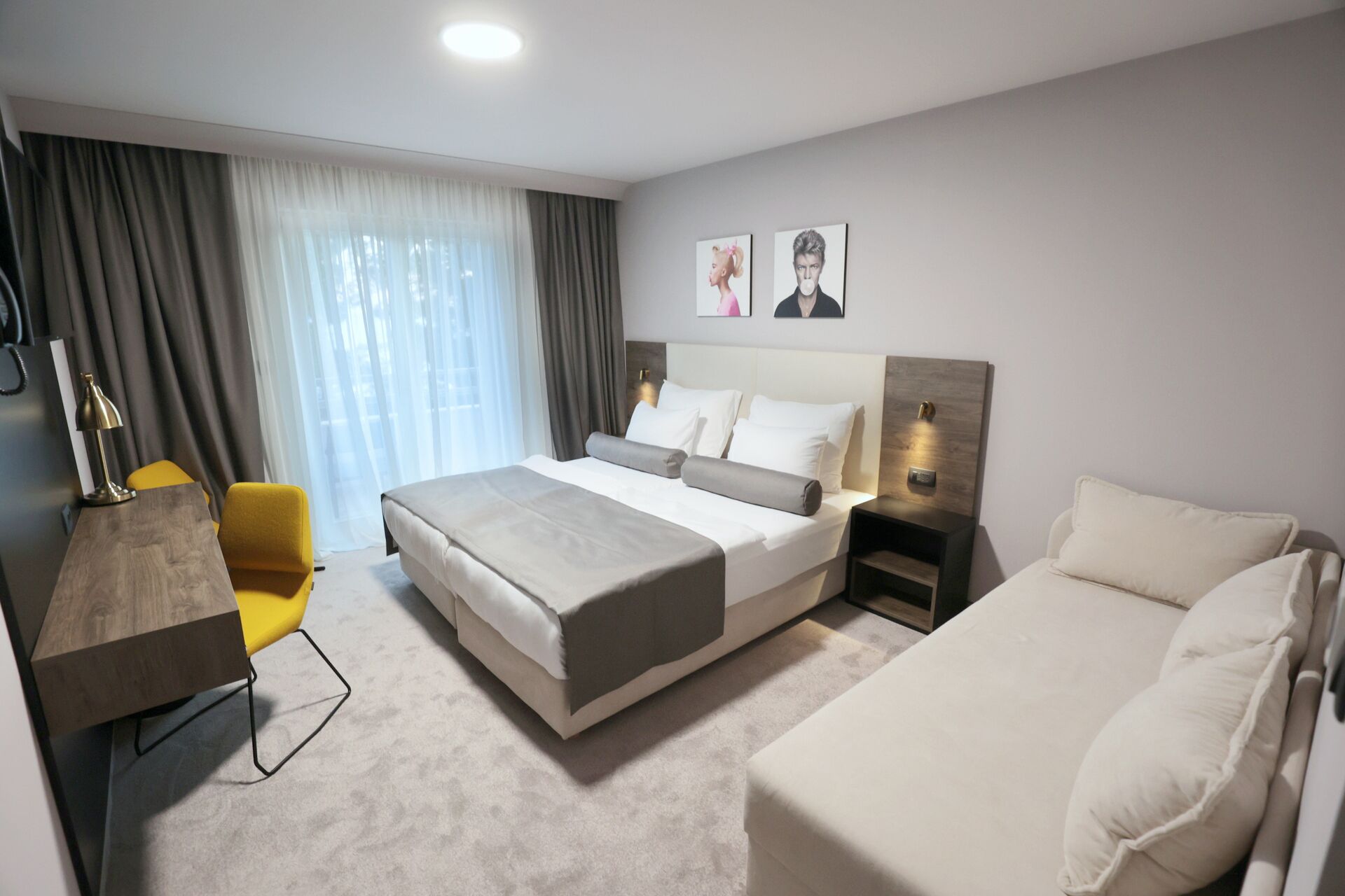 Une chambre d’hôtel moderne avec un grand lit, un bureau, une chaise et un canapé.