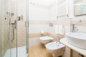 Habitación triple superior | Baño | Ducha, secador de pelo, bidé y toallas