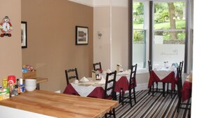 A dining area with striped carpet, wooden chairs, and tables set for a meal. - The Firgarth - Adults Only (Windermere)