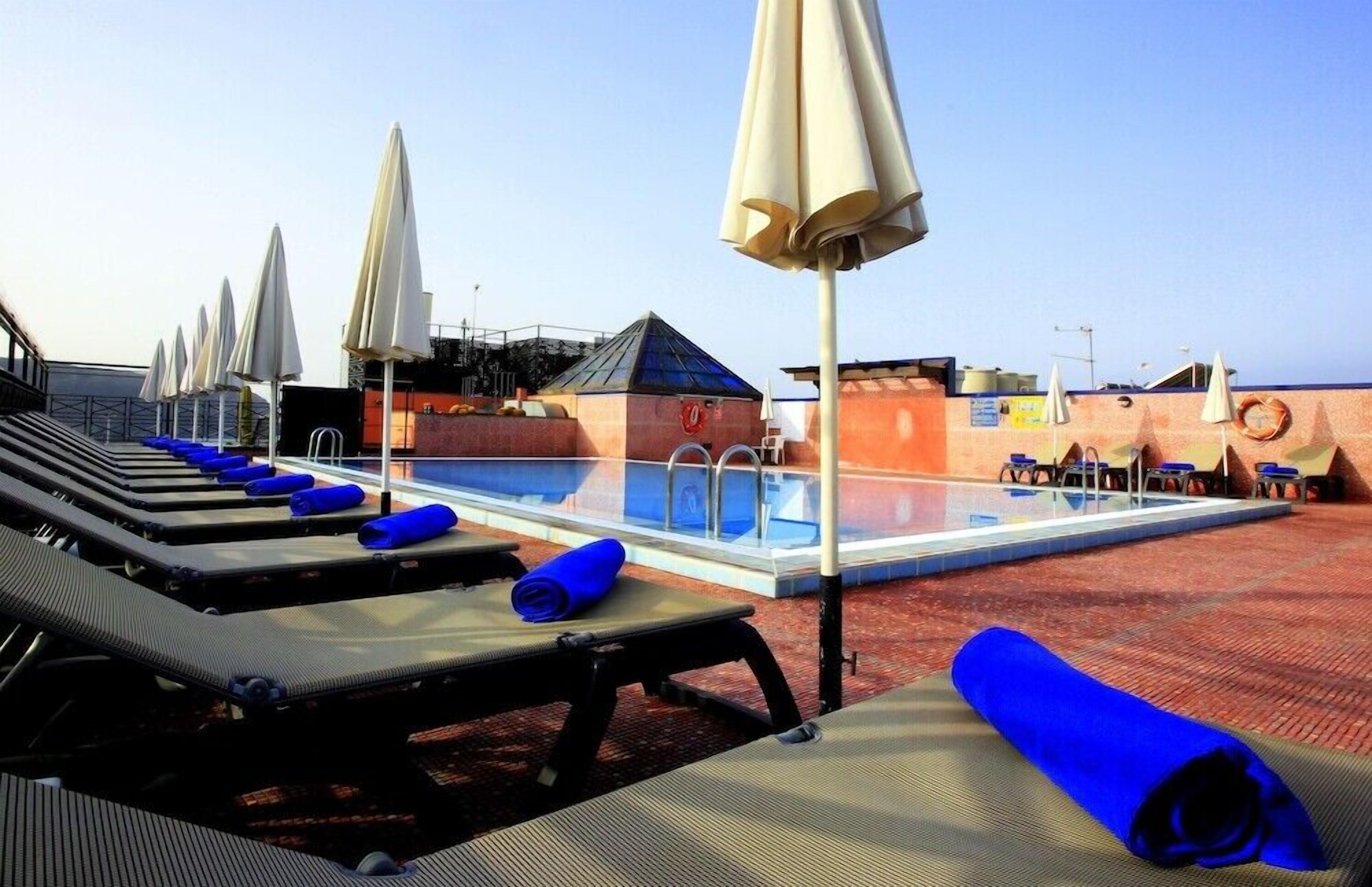 Una piscina al aire libre, tumbonas