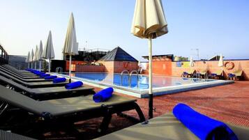 Alberca al aire libre y camastros