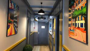 A hallway with a reception sign, a door labeled "Room Access," and a small potted plant. - Hôtel Côte Basque (Bayonne)