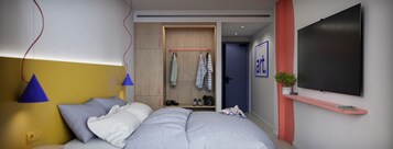 Un dormitorio moderno con cama, lámpara de noche, armario y televisor montado.