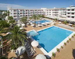 Un hotel con una piscina grande, tumbonas, sombrillas y palmeras.