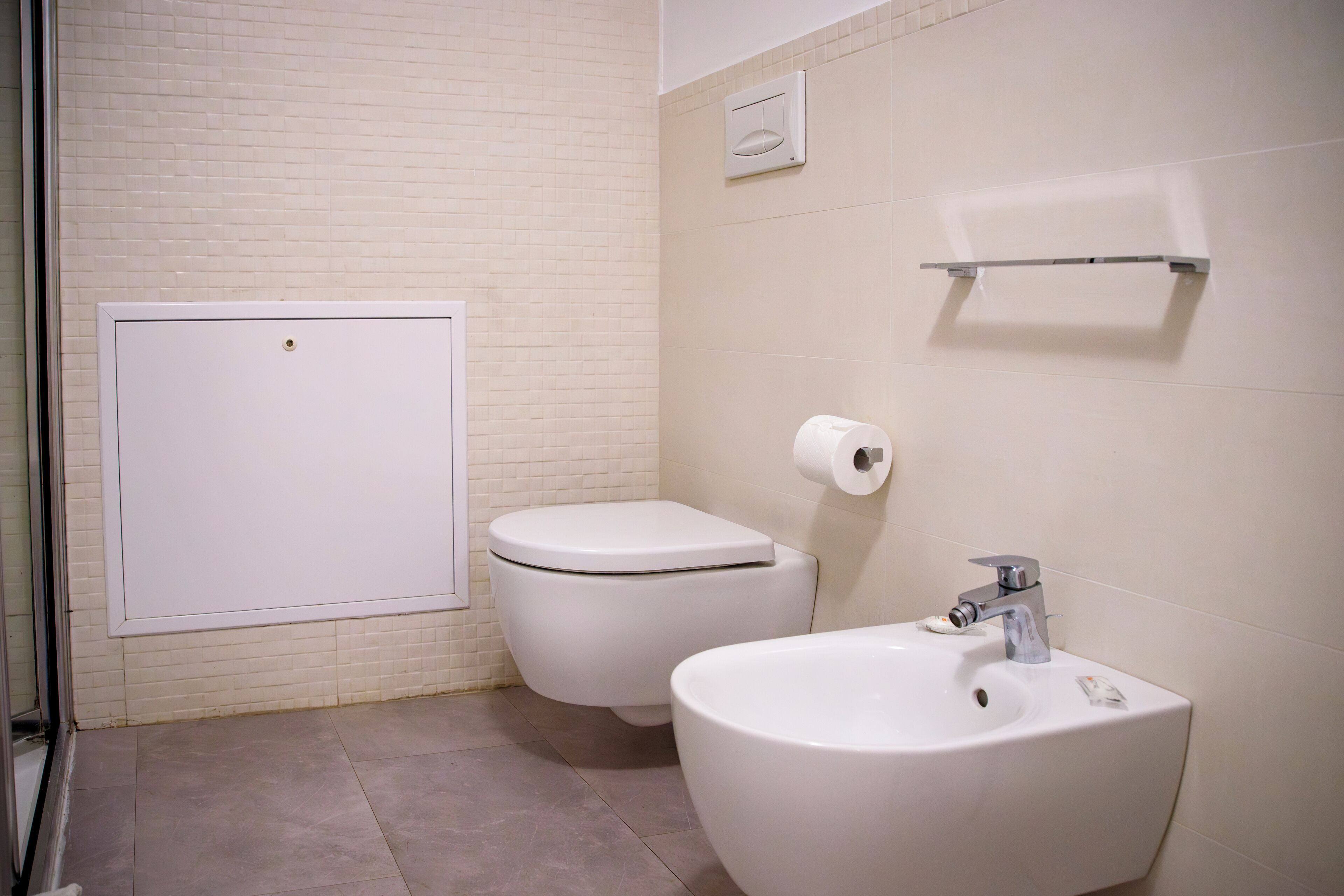 A bathroom with a toilet, bidet, and sink.