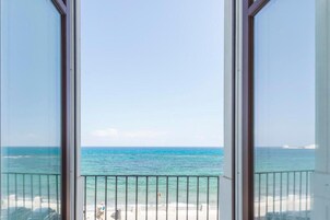 Vista da un balcone su una spiaggia, con cielo sereno.